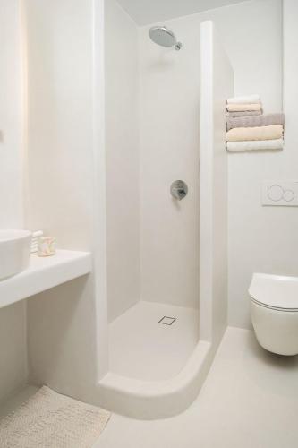 a white bathroom with a shower and a toilet at VotsaLo sea view house in Kastraki
