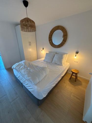 une chambre avec un grand lit avec un miroir dans l'établissement Maison MADA SAINT CAST, à Saint-Cast-le-Guildo