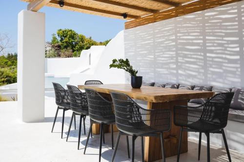 Una mesa y sillas de madera en un patio. en VotsaLo sea view house, en Kastraki Naxou