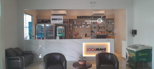 a store with chairs and a counter with a sign at Hotel Mais in Macapá