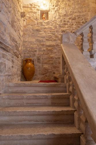 a staircase with a vase in a stone wall at Palazzo Rizzi Dimora dei Templari in Bitetto