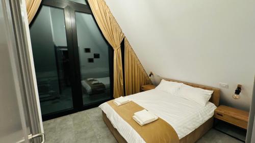 a bedroom with a bed with two towels on it at Rodnei Retreat & Spa in Borşa