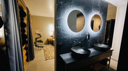 Un baño negro con lavabo y espejo. en Rodnei Retreat, en Borşa