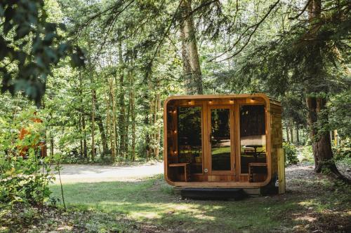 a wooden structure sitting in the middle of a forest at Lumen Nature Retreat in Woodstock