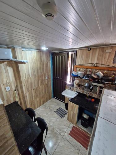 a kitchen with wooden walls and a table and chairs at Kitnets com AR Condicionado na Praia in Salvador