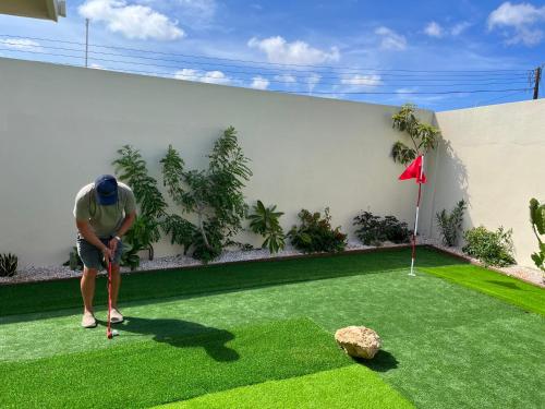 a man playing golf on a putting green at La Villas at Pos Chiquito Caribbean Paradise in Aruba in Savaneta