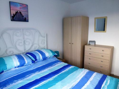 a bedroom with a bed and a dresser at Brambles Chine 209 Self Catering Holiday Home Colwell Bay Isle of Wight - Ferry Offers in Freshwater