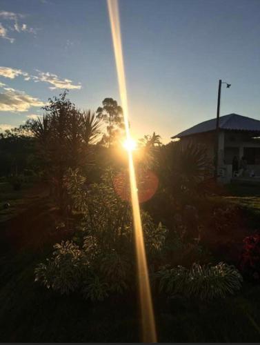 a sun setting over a garden with plants and trees at Sitio Canto da Siriema in Domingos Martins