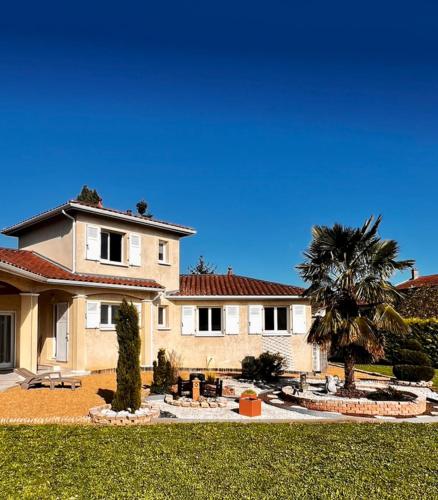 une grande maison avec un palmier en face dans l'établissement Villa Chris-Aurelie, à Les Olmes