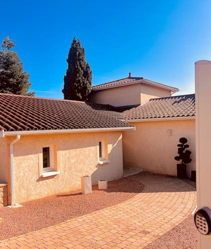 une maison avec une allée en briques devant elle dans l'établissement Villa Chris-Aurelie, à Les Olmes