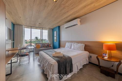 a hotel room with a bed and a balcony at NWTs - Estúdios em Prédio com Vista Mar in Maceió