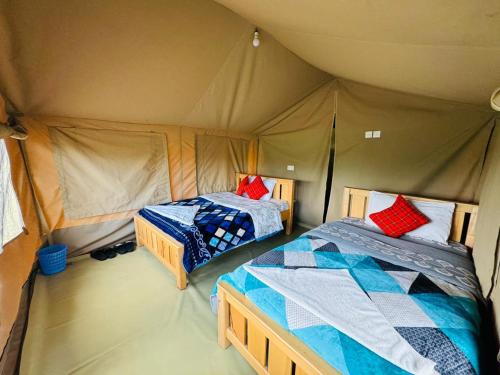 a bedroom with two beds in a tent at Flair Camp Experiences in Ololaimutiek