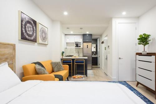 ニューヨークにある1597-8 Luxury STUDIO Upper East Side W&Dのリビングルーム(ベッド1台付)、キッチンが備わります。