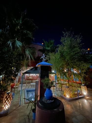 a patio at night with a blue vase and lights at Riad Dades Birds in Boumalne