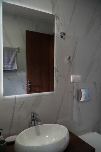 a bathroom with a white sink and a mirror at Aether Home with view in Kalabaka
