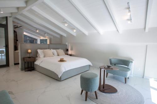 Un dormitorio con una cama grande y una silla. en Ionian Elite Beachfront Villa, en Nydri