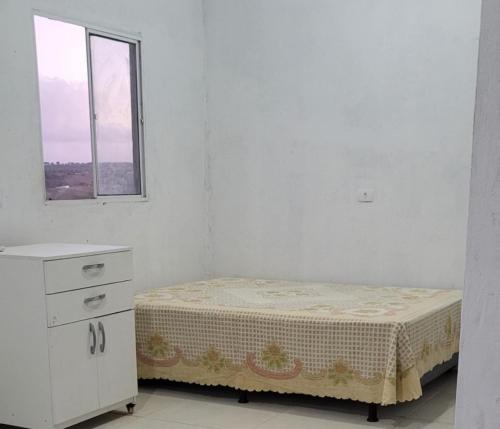 a small bed in a white room with a window at Marina's in Pau dʼAlho