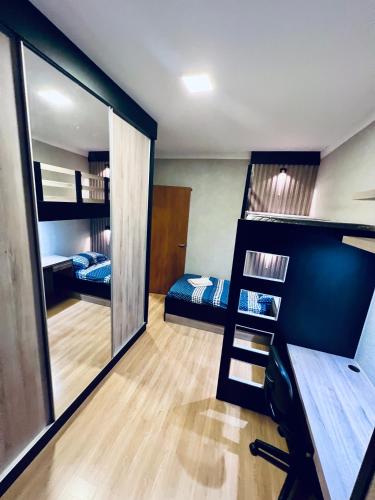 a room with two bunk beds and a mirror at Moderno Sobrado Climatizado com Ar Quente e Frio in Cascavel