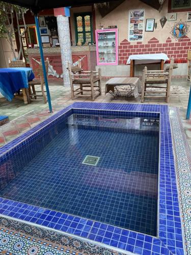 a swimming pool with blue tiles on the ground at Riad Dades Birds in Boumalne