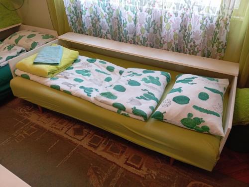 a bed with two pillows on it in a room at Green Cactus Rooms - unique and cozy house in Senta