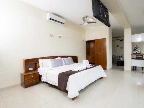 a bedroom with a large bed with a television on the wall at Hotel San Marino Tarapoto in Tarapoto