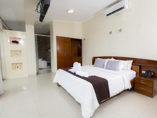 a bedroom with a large bed with white sheets and pillows at Hotel San Marino Tarapoto in Tarapoto