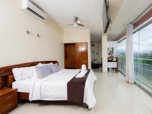 a bedroom with a large bed and a balcony at Hotel San Marino Tarapoto in Tarapoto