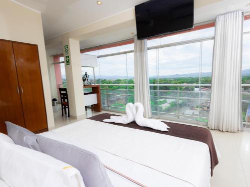 a bedroom with a large bed with a large window at Hotel San Marino Tarapoto in Tarapoto