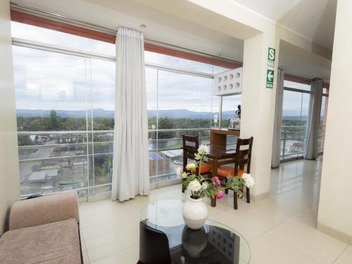 a living room with a table and chairs and a large window at Hotel San Marino Tarapoto in Tarapoto