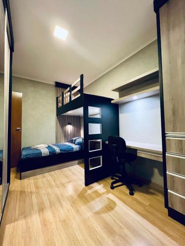a bedroom with bunk beds and a desk in it at Moderno Sobrado Climatizado com Ar Quente e Frio in Cascavel