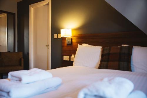 a hotel room with a bed with towels on it at The Portree Hotel in Portree