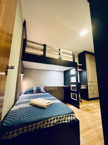 a bedroom with two bunk beds and a blue bed at Moderno Sobrado Climatizado com Ar Quente e Frio in Cascavel
