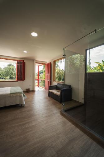 a bedroom with a bed and a glass wall at Finca Hotel in Armenia