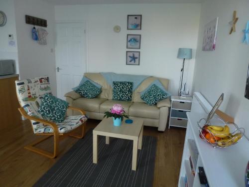 a living room with a couch and a table at Brambles Chine 209 Self Catering Holiday Home Colwell Bay Isle of Wight - Ferry Offers in Freshwater