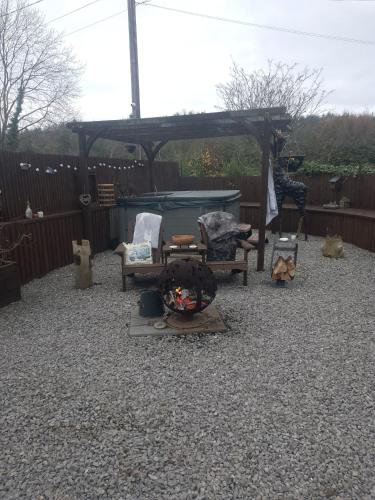 a patio with a gazebo and chairs in a yard at The Stables in Gloucestershire