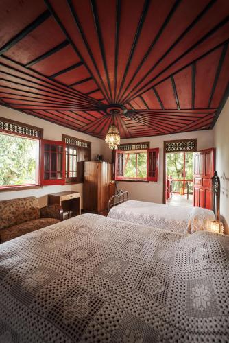 a bedroom with a large bed with a wooden ceiling at Finca Hotel in Armenia