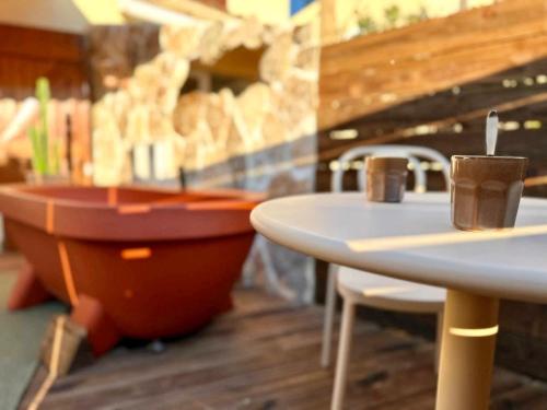 a room with two tables and a bath tub at Superbe Maison - Bain Chaud ou Froid & Cinema - Cap d'Agde in Cap d'Agde