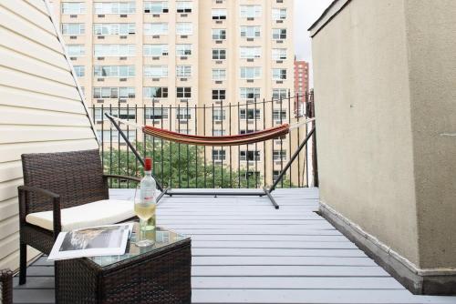 a balcony with a table and a bottle of wine at 1597-PHS New 1BR-2bath PH Duplex Outdoor Deck in New York