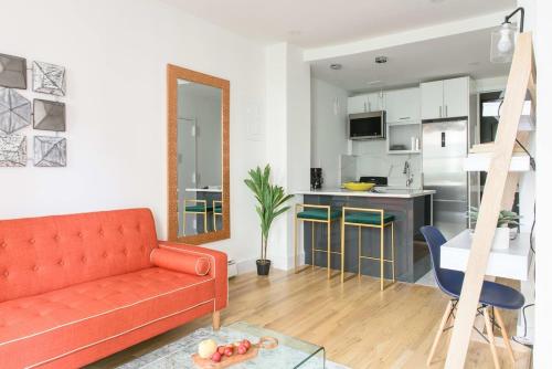 a living room with a red couch and a kitchen at 1597-PHS New 1BR-2bath PH Duplex Outdoor Deck in New York