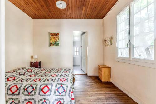 a bedroom with a bed and a wooden ceiling at Maison charmante à Soulac-sur-Mer avec jardin clôturé in Soulac-sur-Mer