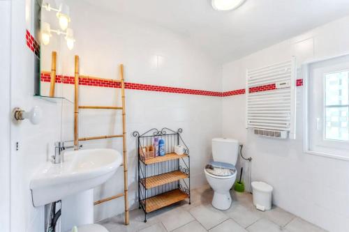a white bathroom with a sink and a toilet at Maison charmante à Soulac-sur-Mer avec jardin clôturé in Soulac-sur-Mer