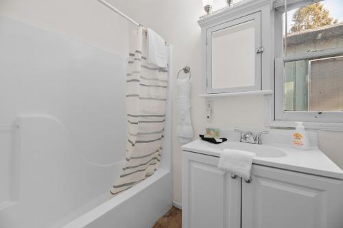 a white bathroom with a sink and a window at Hideaway Cabin - Cozy romantic cabin perfect for couples in Big Bear City