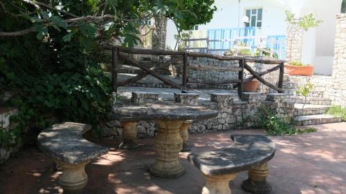 a stone bench with two seats next to a stone wall at Santa Lucia-Park Coppa della Nuvola in Peschici