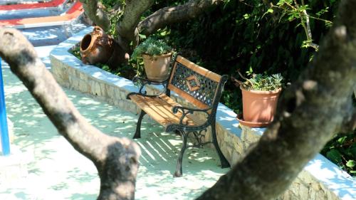 a wooden bench sitting next to some potted plants at Santa Lucia-Park Coppa della Nuvola in Peschici
