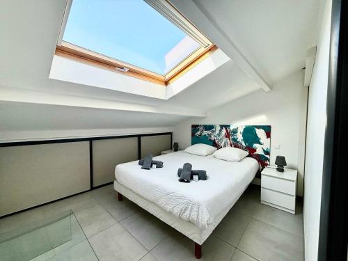 une chambre avec un grand lit avec une lucarne dans l'établissement Casamea - Plage 20m, Vue Mer, Famille, à Porticcio