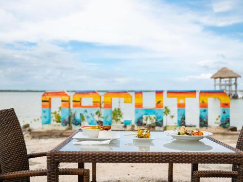 a table with plates of food on the beach at Orchid Bay Resort in Corozal