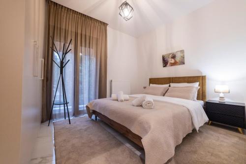 a bedroom with a large bed with towels on it at Filoxenia Luxury apartments Trikala in Tríkala