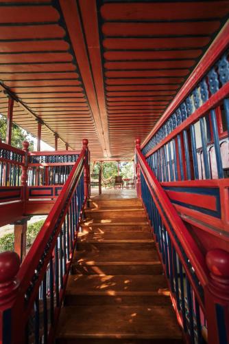 a wooden walkway with red and blue railing on a bridge at Finca Hotel in Armenia