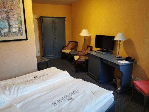 a hotel room with a bed and a desk with a computer at Hotel & Spa Wasserschloss Westerburg in Westerburg