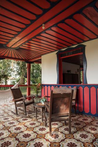 a porch with two chairs and a table and a mirror at Finca Hotel in Armenia